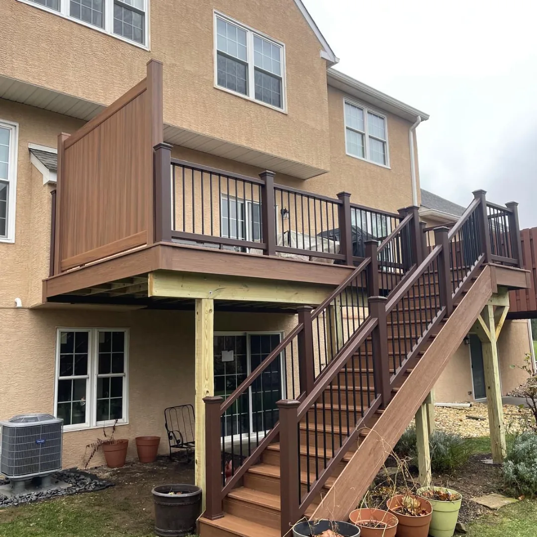 Multi-level brown composite deck with privacy wall.