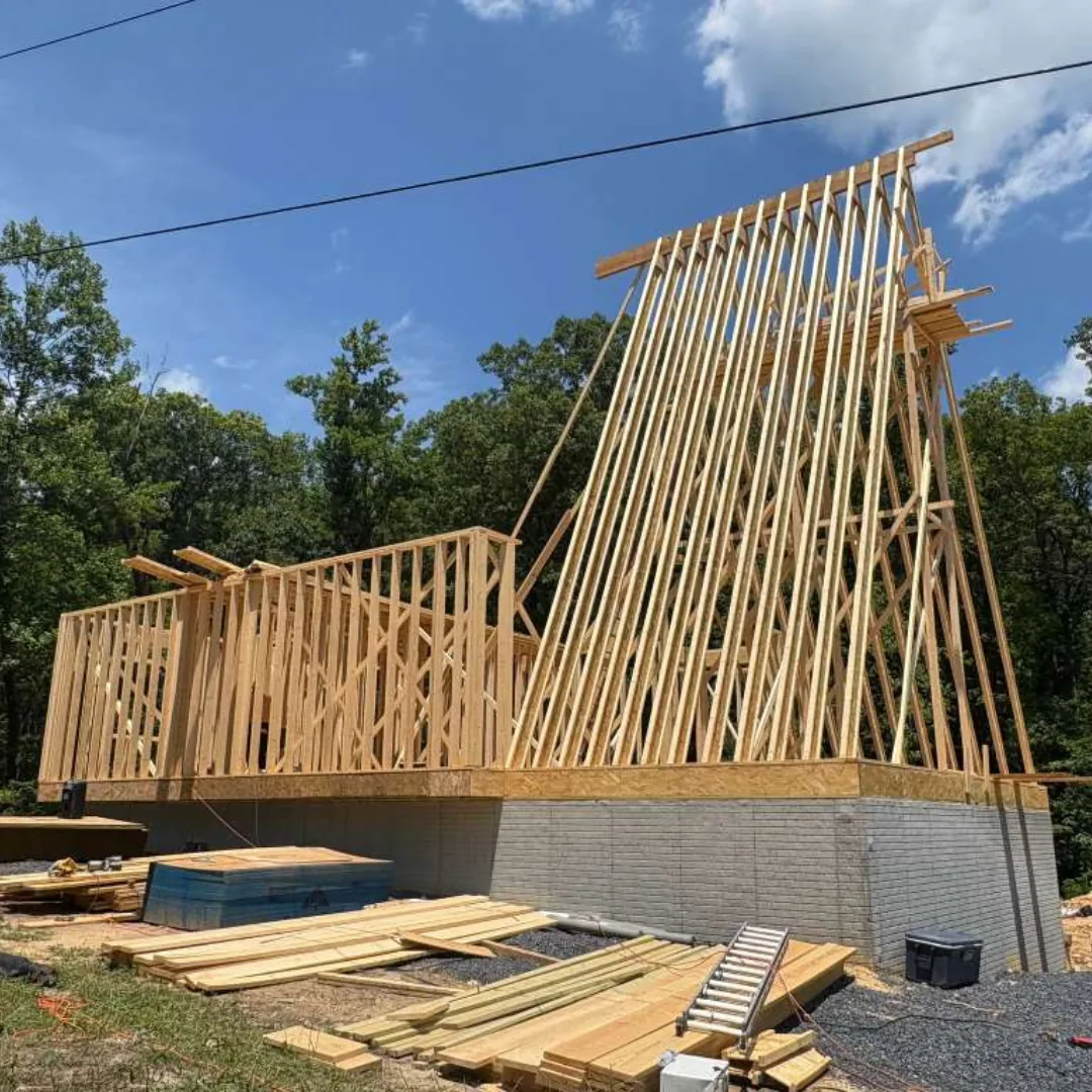 New home construction framing with tall roof trusses.