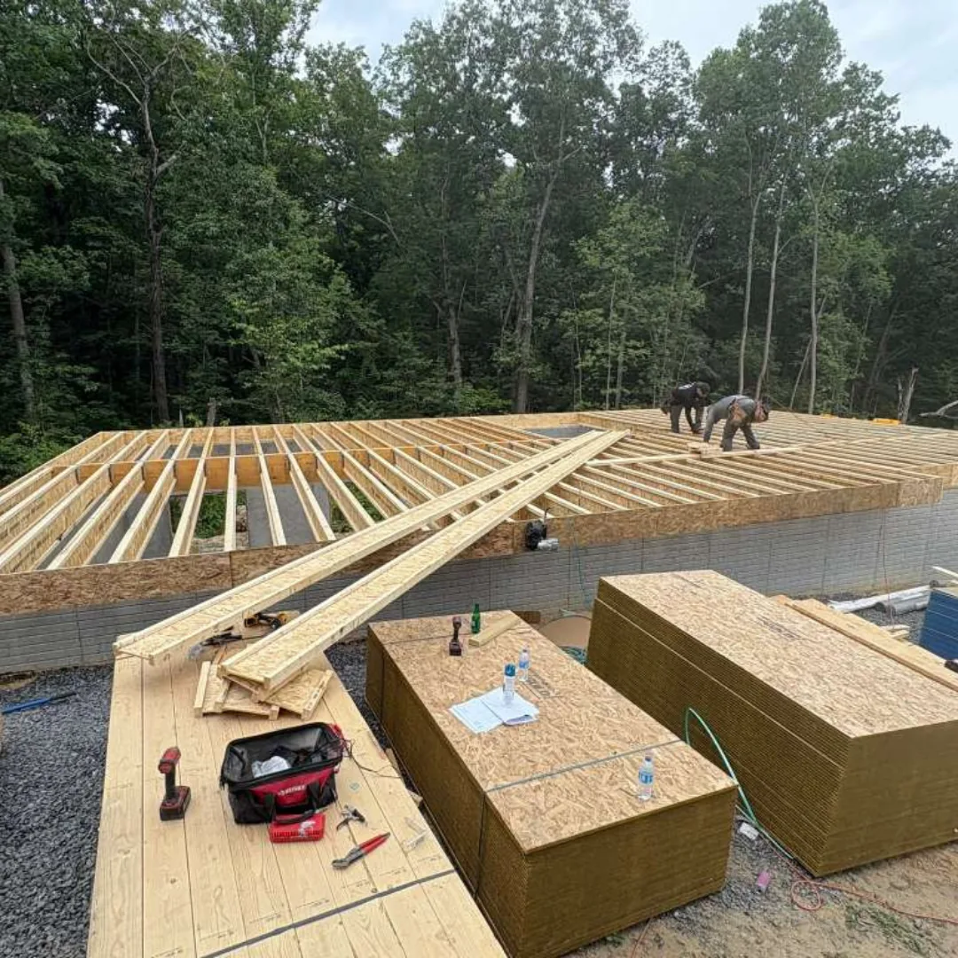Workers constructing a subfloor and wall framing.