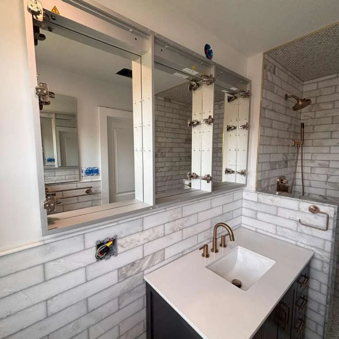 Bathroom with vanity, mirror, and tiled shower.