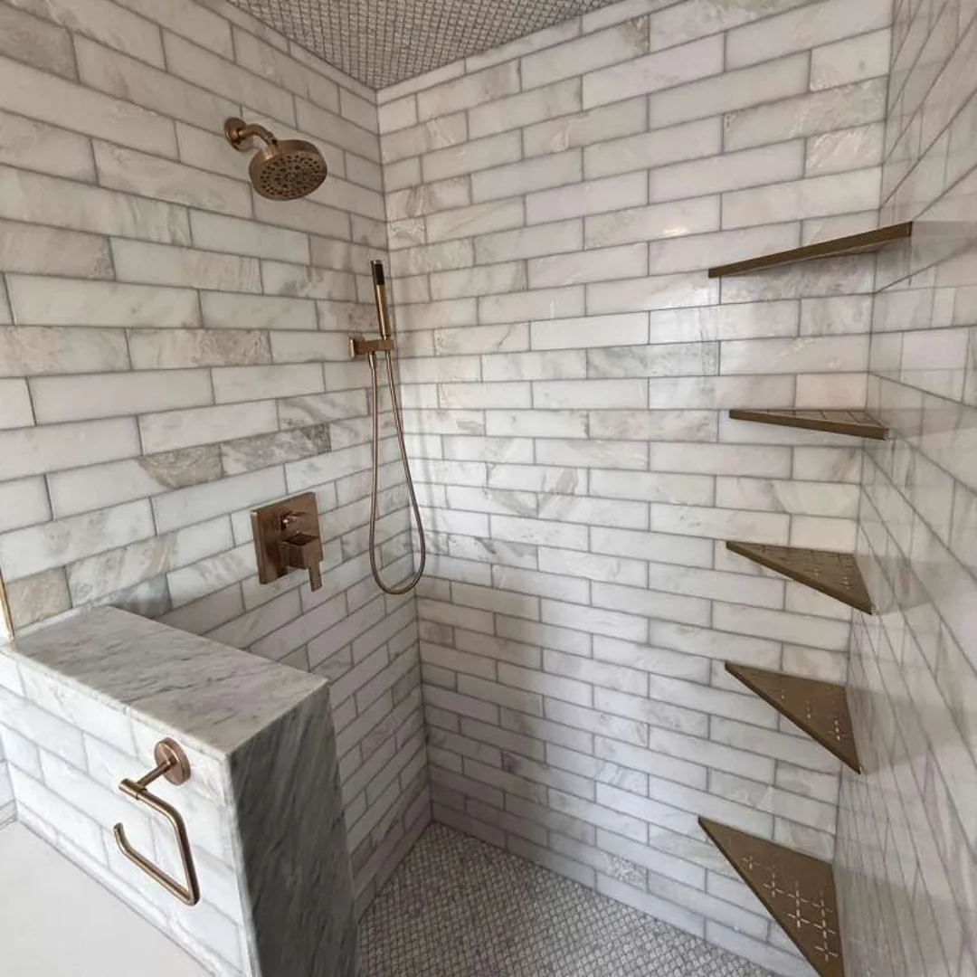 Marble subway tile shower with bronze fixtures.