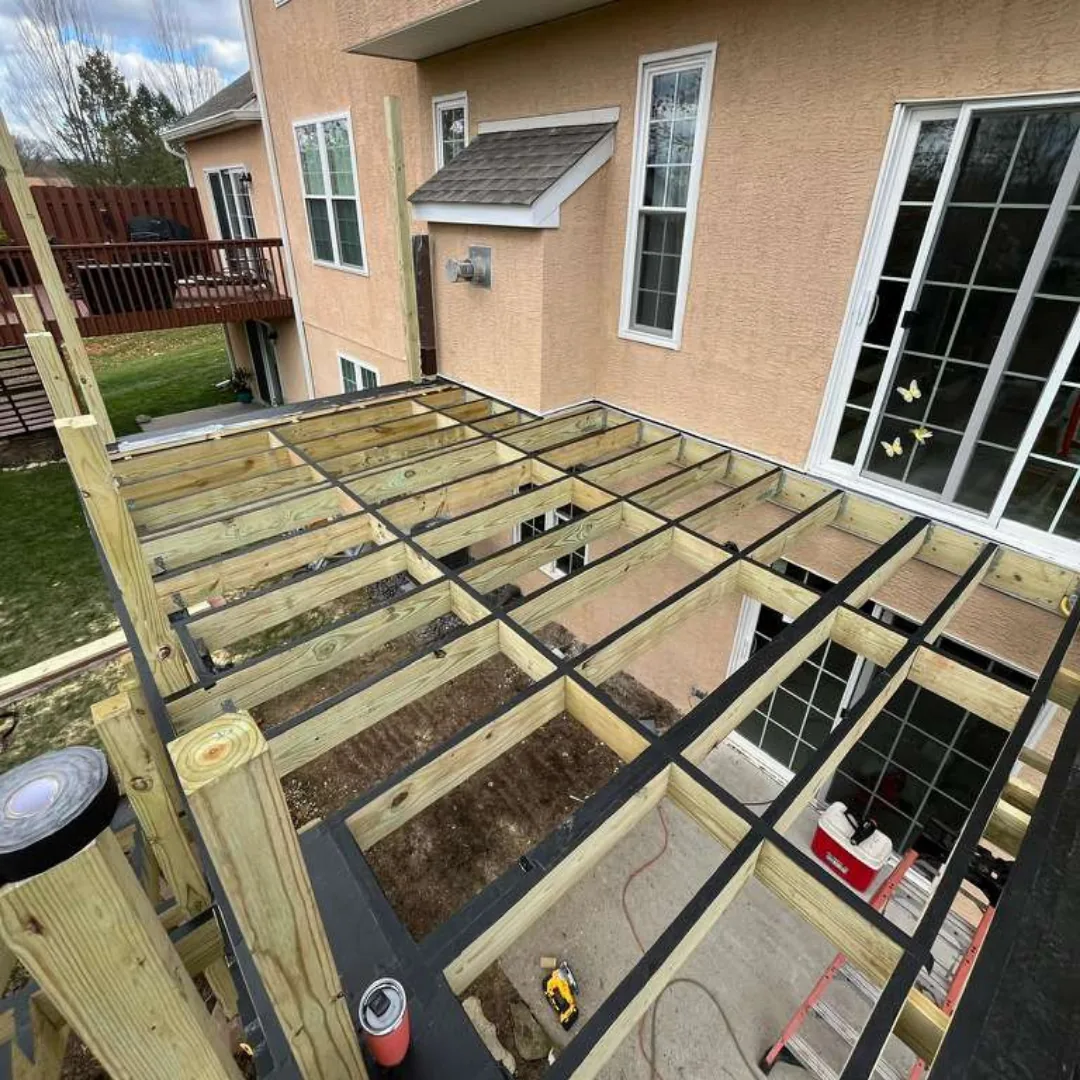 Deck framing under construction with treated lumber.