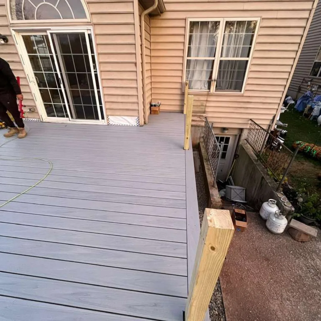 New gray composite deck installation with wood posts