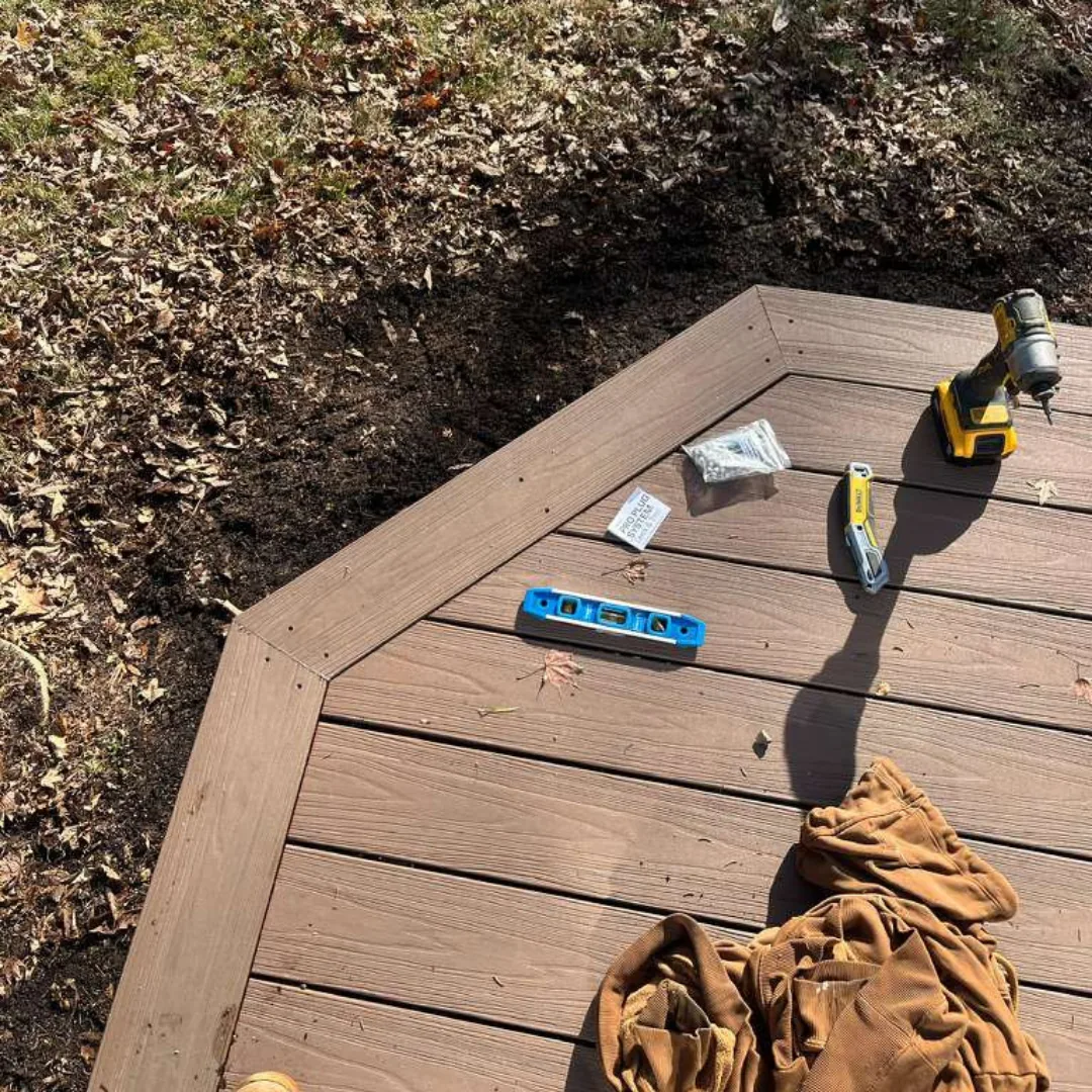 Deck construction with tools and screws on new composite boards.