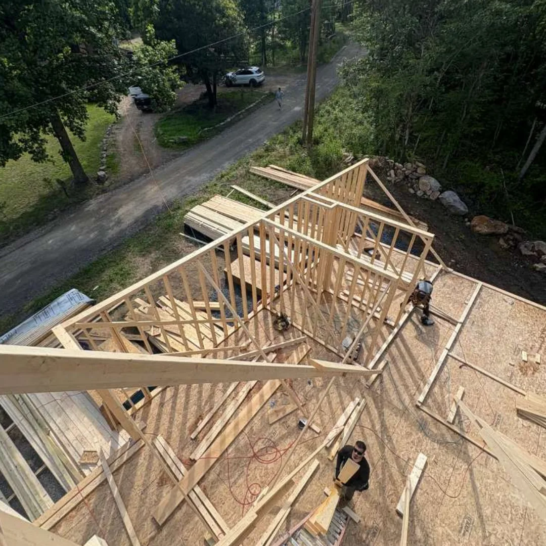 Workers constructing roof trusses on a new home.