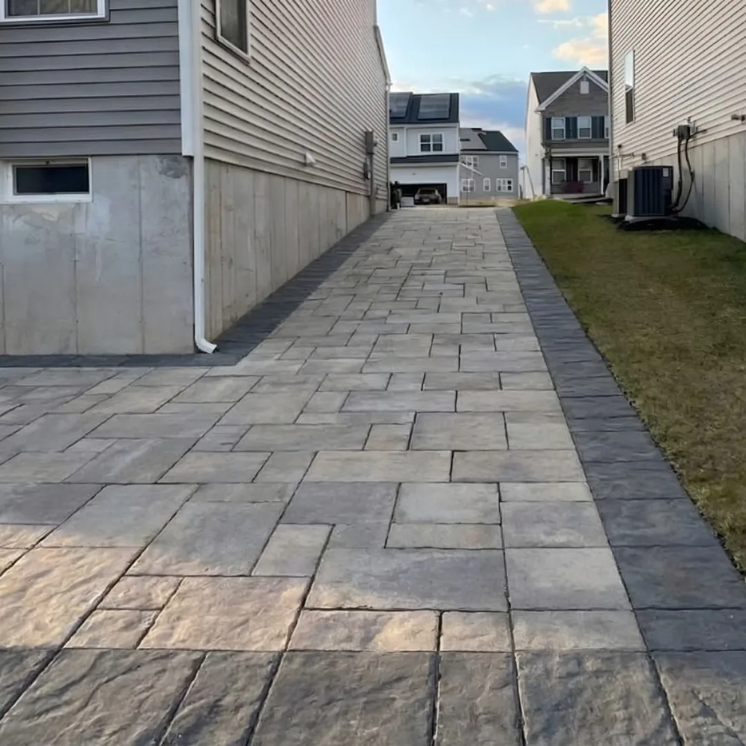 Paver stone walkway between two houses.