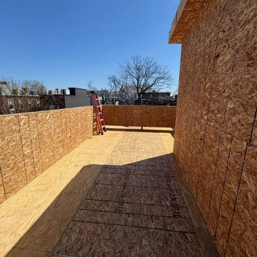 Rooftop deck under construction, bare OSB walls