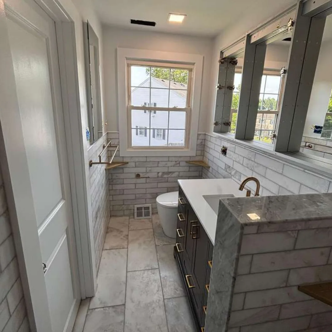 Renovated bathroom with white subway tile and vanity.