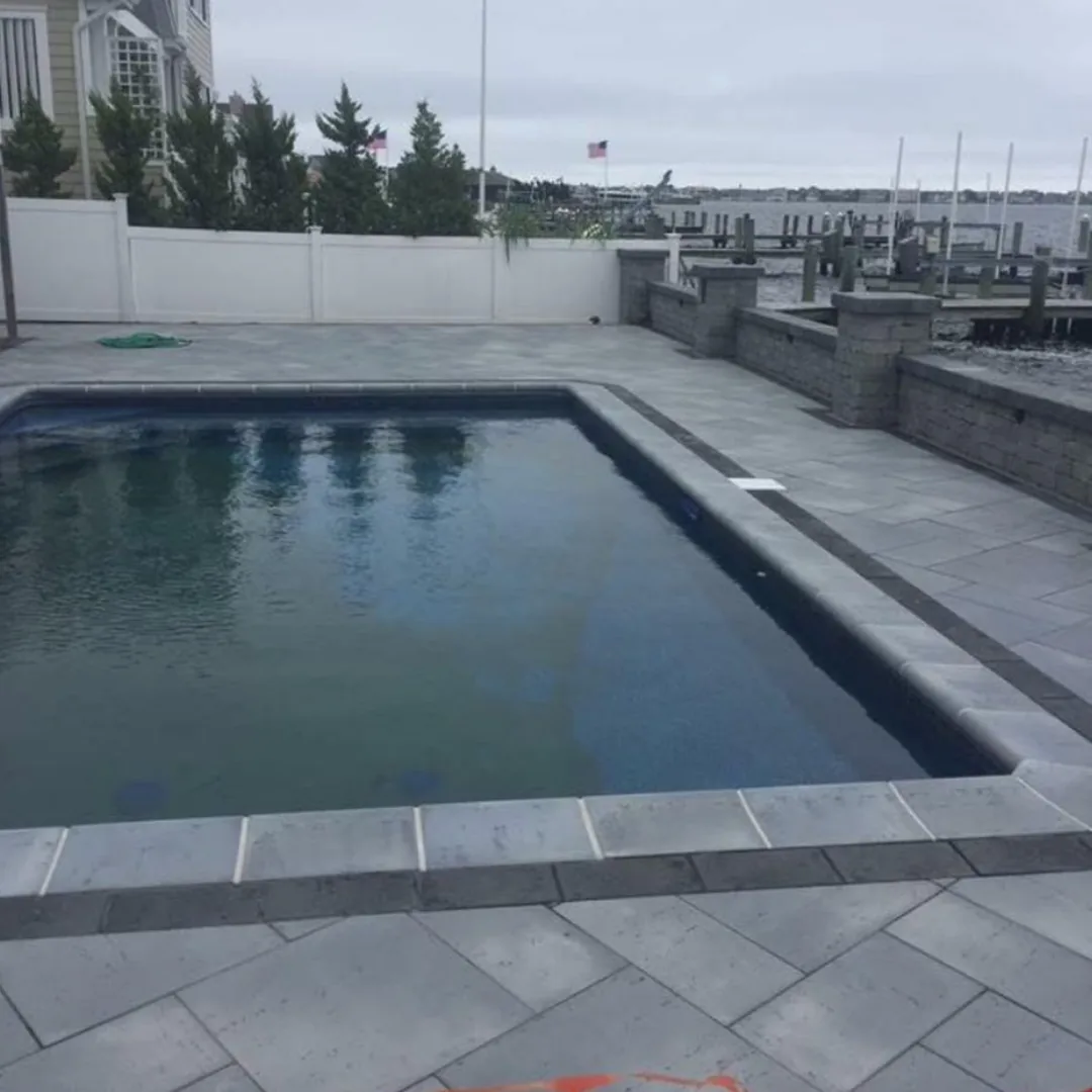 Poolside patio with stone pavers and retaining wall