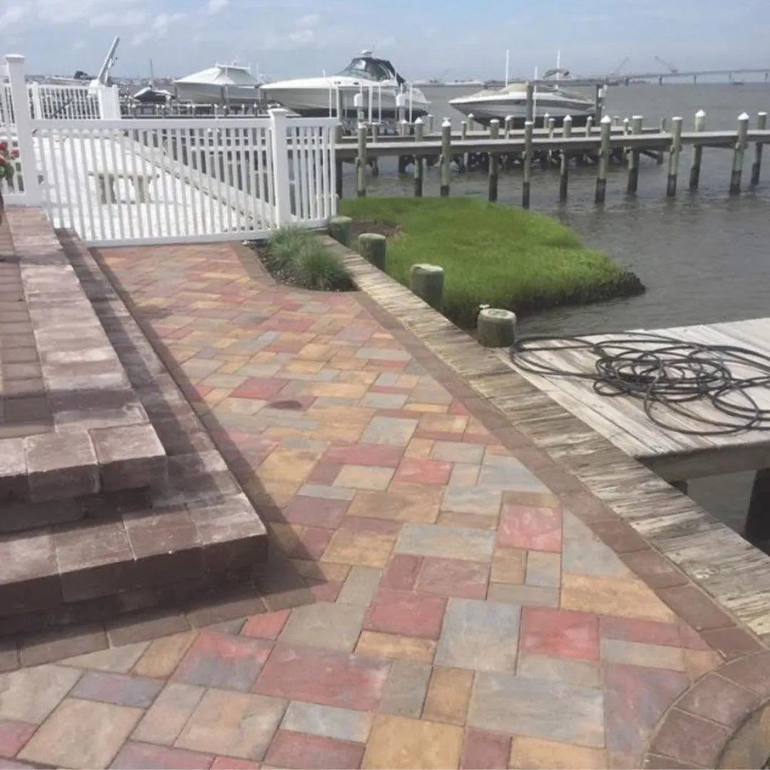 Colorful paver patio and walkway by water.